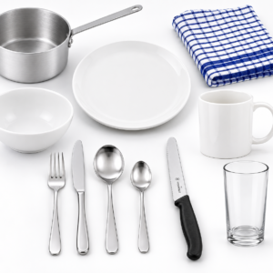 Kitchen Essentials Kit Lite flat lay showing saucepan, dinner plate, bowl, ceramic mug, water glass, 4-piece cutlery set, Victorinox vegetable knife, and tea towel on white background